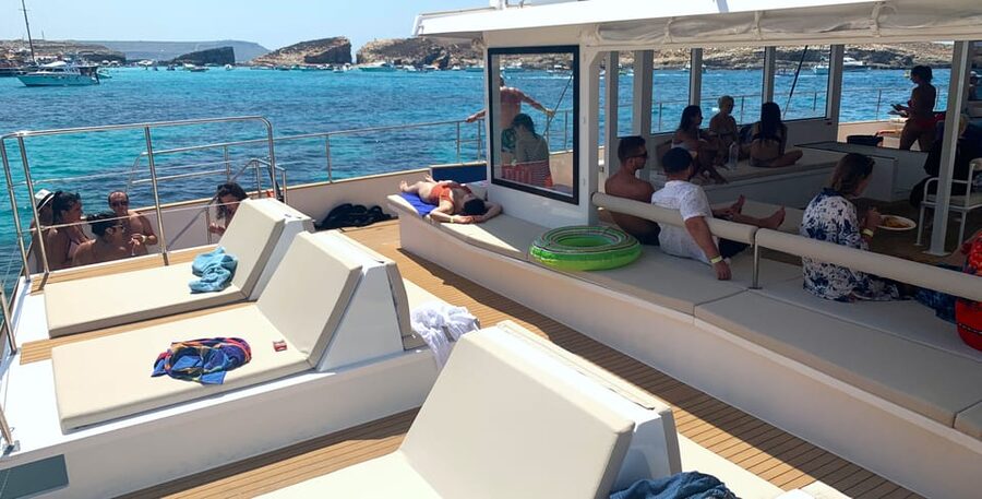Malta: Blue Lagoon Evening Catamaran Cruise - Anchor Bay and the Popeye Village view